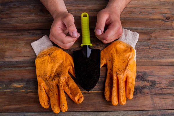 Pair of gloves, trowel and males hands - gardening concept. — 스톡 사진