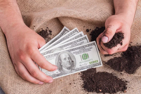 Mans hand holding money and soil. — 스톡 사진