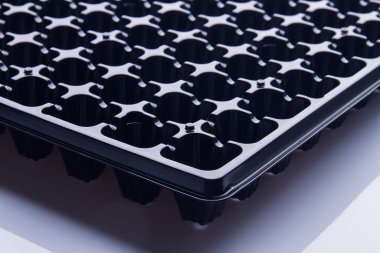 Extreme close-up black seeding tray cells.