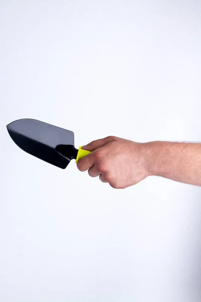 Mans hand holding gardening trowel. — Stockfoto