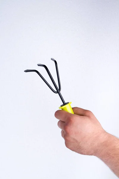 Holding small three-jaw garden rake. — Stockfoto