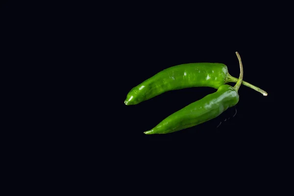 Siyah arkaplanda yeşil biber. — Stok fotoğraf