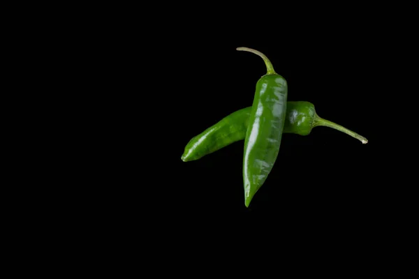 Vainas de pimiento verde caliente sobre fondo negro . — Foto de Stock