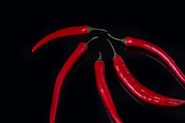Grupo de pimentas vermelhas no fundo preto . — Fotografia de Stock