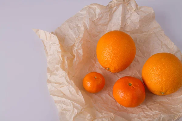 Апельсины и клементины на пергаменте . — стоковое фото
