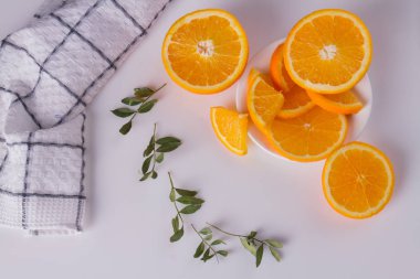 Dilimlenmiş portakal ve yeşil yapraklar.