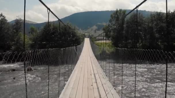 Holzbrücke über den Gebirgsfluss. — Stockvideo