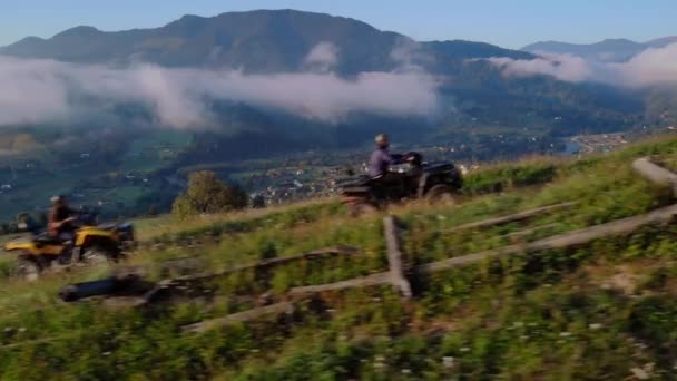 Män rider på fyrhjulingar på dimmiga berg bakgrund. — Stockvideo