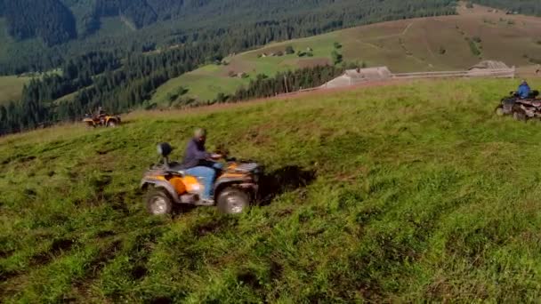 Folk rider fyrhjulingar på kullen. — Stockvideo