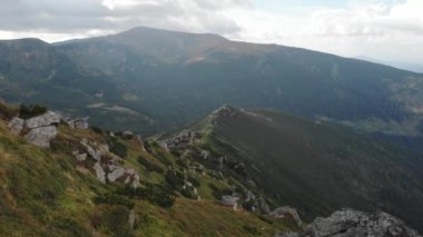 Kayalık dağların manzarası ve bulutlu gökyüzü.