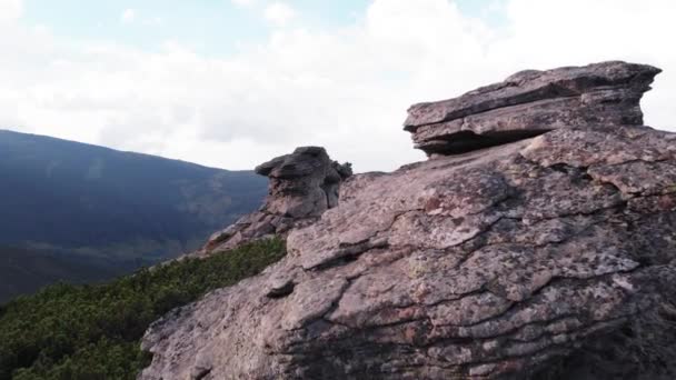 Huge rocky formation on the edge of a grassy slope. — Stock Video