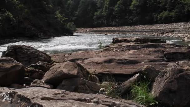 Kıyısında büyük kayalar olan dağ nehri manzarası. — Stok video