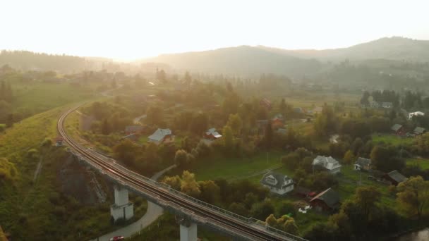 Bergdorf im Tal und Eisenbahnbrücke. — Stockvideo