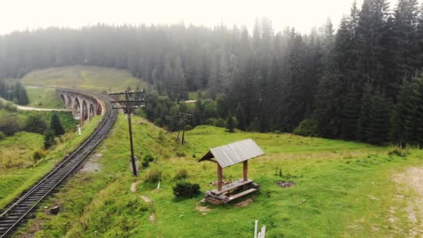 Eski bir demiryolu köprüsü ile nefes kesici bir dağ manzarası. — Stok video