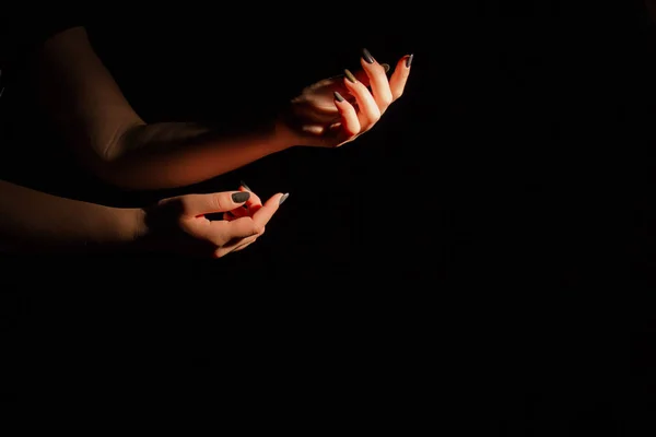 Tender female holding hands isoalted on black background. — Stock Photo, Image