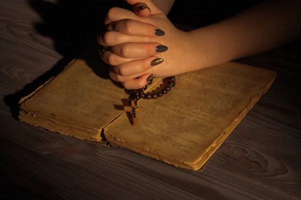 Bidden tot God, gevouwen christelijke vrouw handen met heilige bijbel en rozenkrans. — Stockfoto
