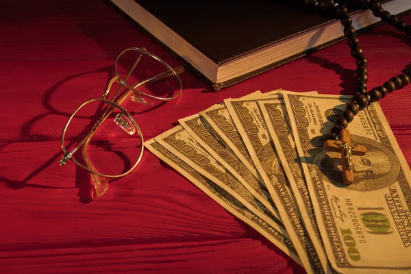 Rosary beads, money, glasses and holy bible. — Stock Photo, Image