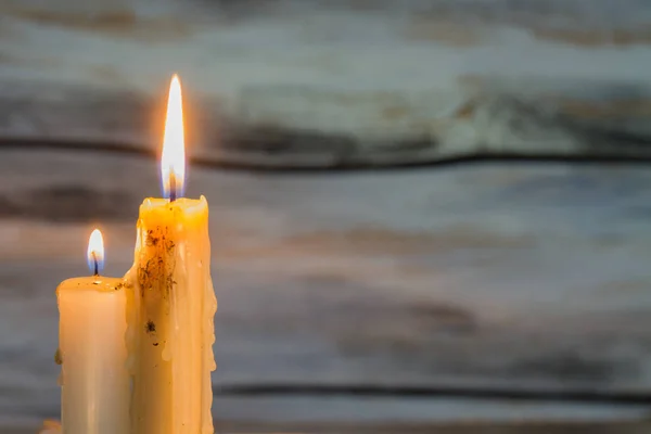 Dos velas encendidas sobre fondo de madera . —  Fotos de Stock