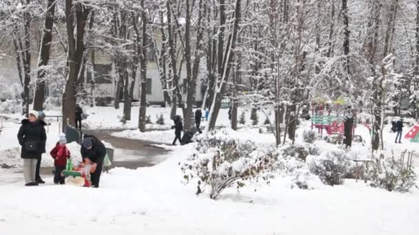 Karla kaplı kalabalık şehir parkı. — Stok video