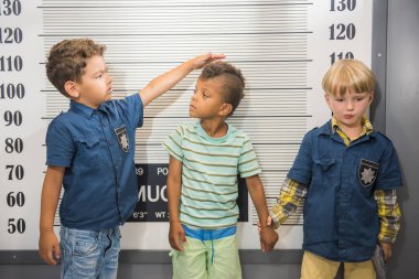 Elementary school boys playing police and prisoner.