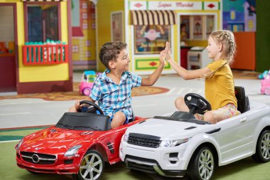 Little boy and girl playing in entertainment center.