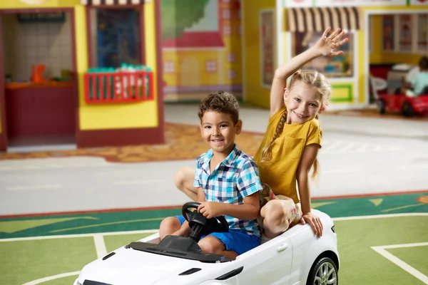 保育園のおもちゃの車に座っている幸せな子供たち. — ストック写真