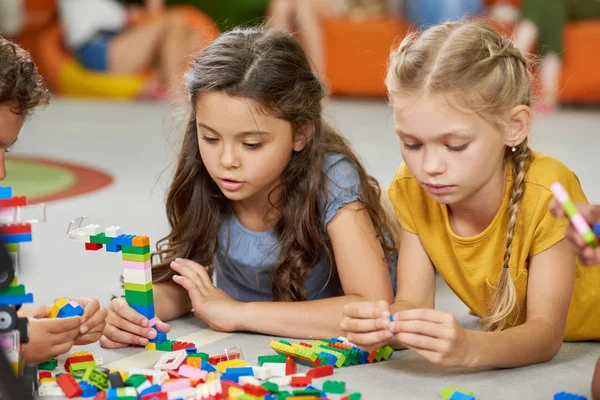 Groep kinderen die speelgoed blokken spelen. — Stockfoto