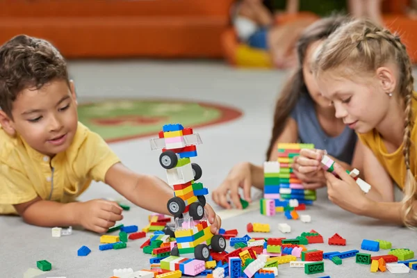 Kleine meisjes en jongens spelen met blokken. — Stockfoto