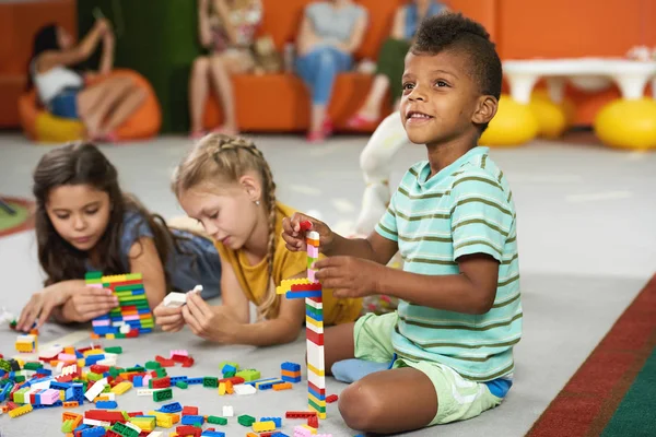 Spelende kinderen blokkeren speelgoed in de speelkamer op kwekerij. — Stockfoto