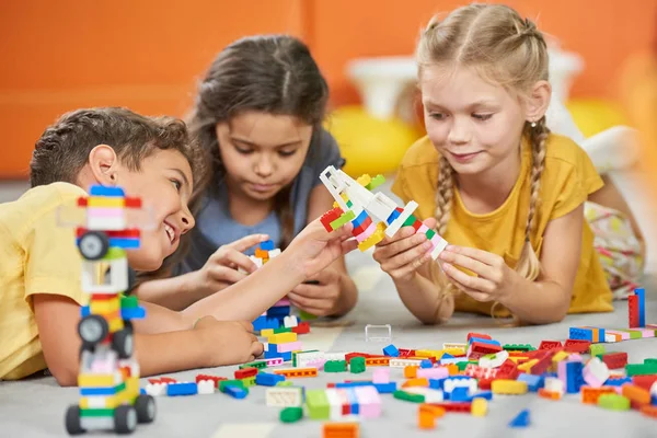 Groep kinderen spelen met plastic blokken. — Stockfoto