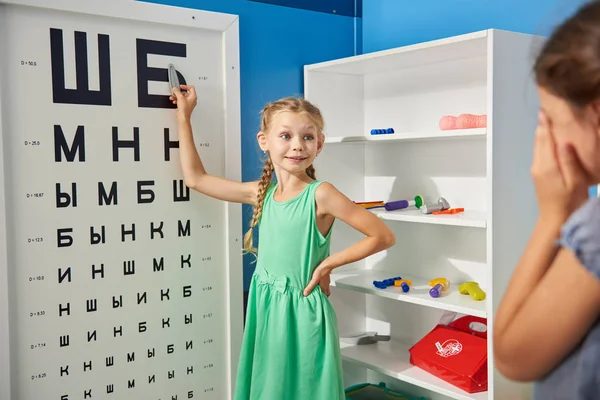 Kids playing doctor in playroom or kindergarten.