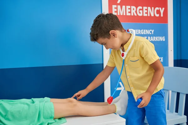 Petit garçon et fille jouant docteur dans la salle de jeux . — Photo