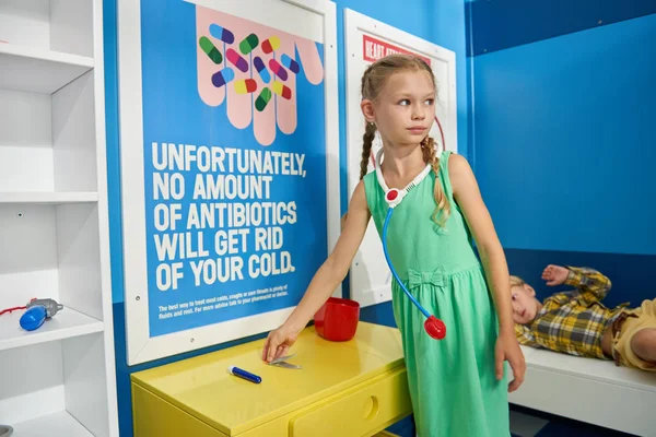 Enfants jouant médecin et patient au cabinet des médecins . — Photo