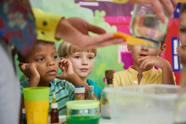 Skupina zvědavých dětí sledujících chemický experiment v herně. — Stock fotografie