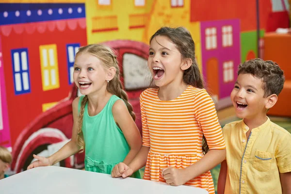 Tres niños emocionales en la sala de juegos . — Foto de Stock