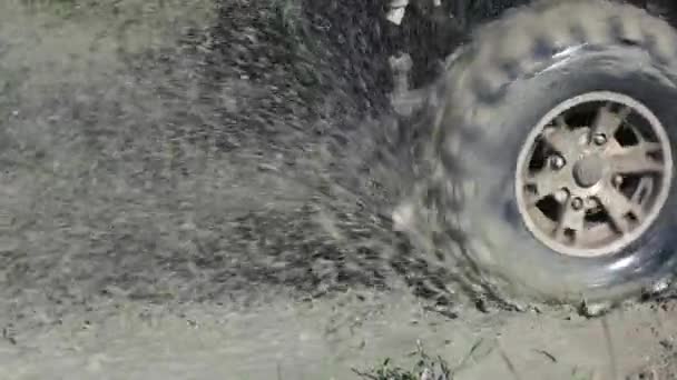 Snurrande offroad hjul stänk smuts vatten. — Stockvideo