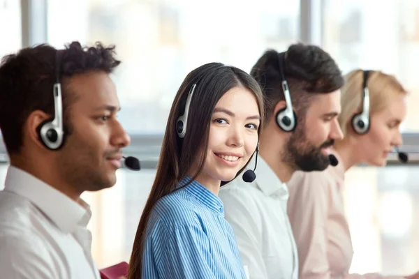 Asiatische junge Arbeiterin sitzt in hellem Büro in einem Unternehmen. — Stockfoto