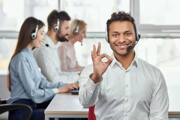 Indian call center agent shows ok gesture.