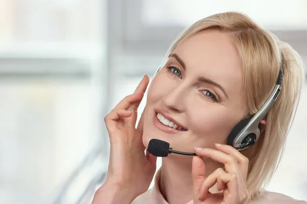 Rubia madura mujer de negocios con auriculares hablando . — Foto de Stock