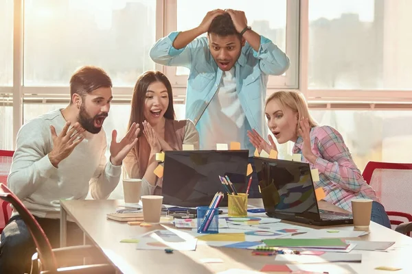 Persone creative stupite in ufficio chiedendosi guardando lo schermo del computer portatile . — Foto Stock