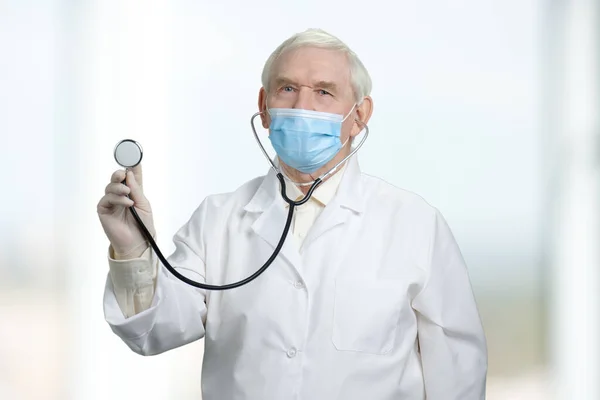 Gammal läkare hålla stetoskop. — Stockfoto