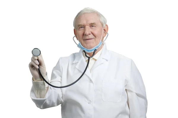 Alter Arzt mit Stethoskop in der Hand auf weißem Hintergrund. — Stockfoto
