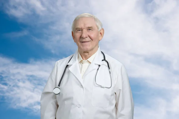 Médico caucasiano sorridente usando estetoscópio . — Fotografia de Stock