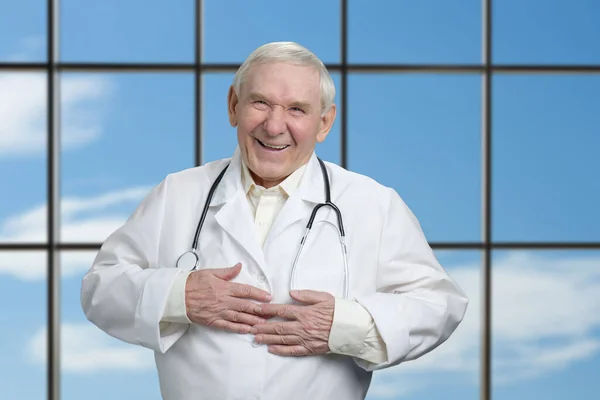 Velho médico está rindo segurando estômago . — Fotografia de Stock