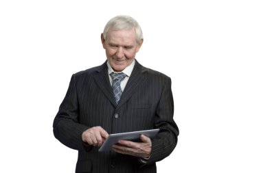 Senior in suit swiping tablet.