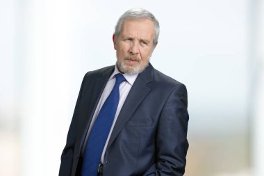 Portrait of serious older businessman in suit.