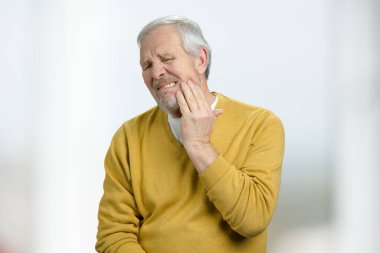 Portrait of old man suffering from toothache.