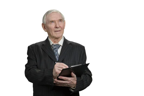 Senior businessman looks up and writing down. — Stock Photo, Image