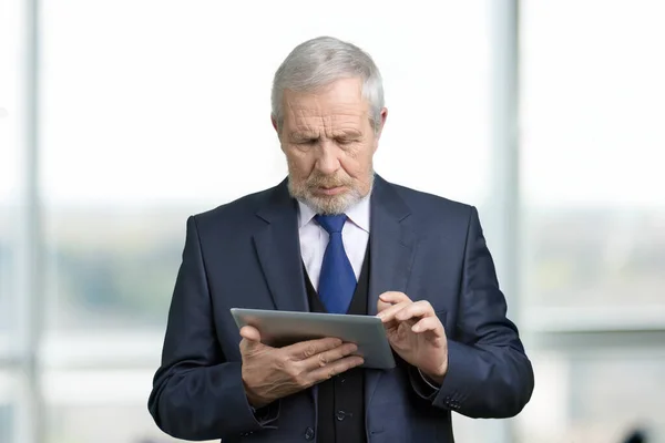 Old manager tapping tablet. — Stock Photo, Image