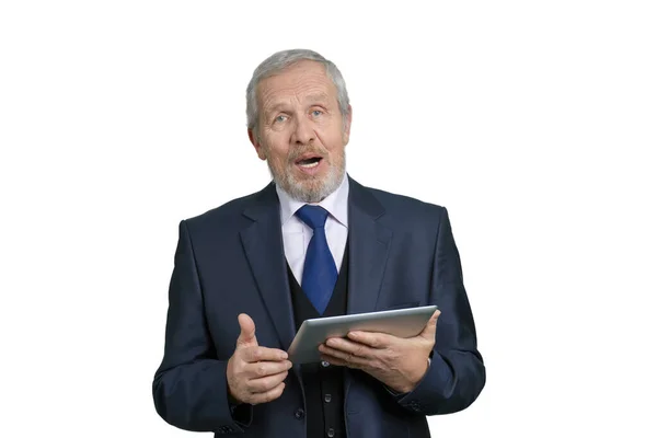 Viejo hombre de negocios hablando, sosteniendo la tableta . — Foto de Stock